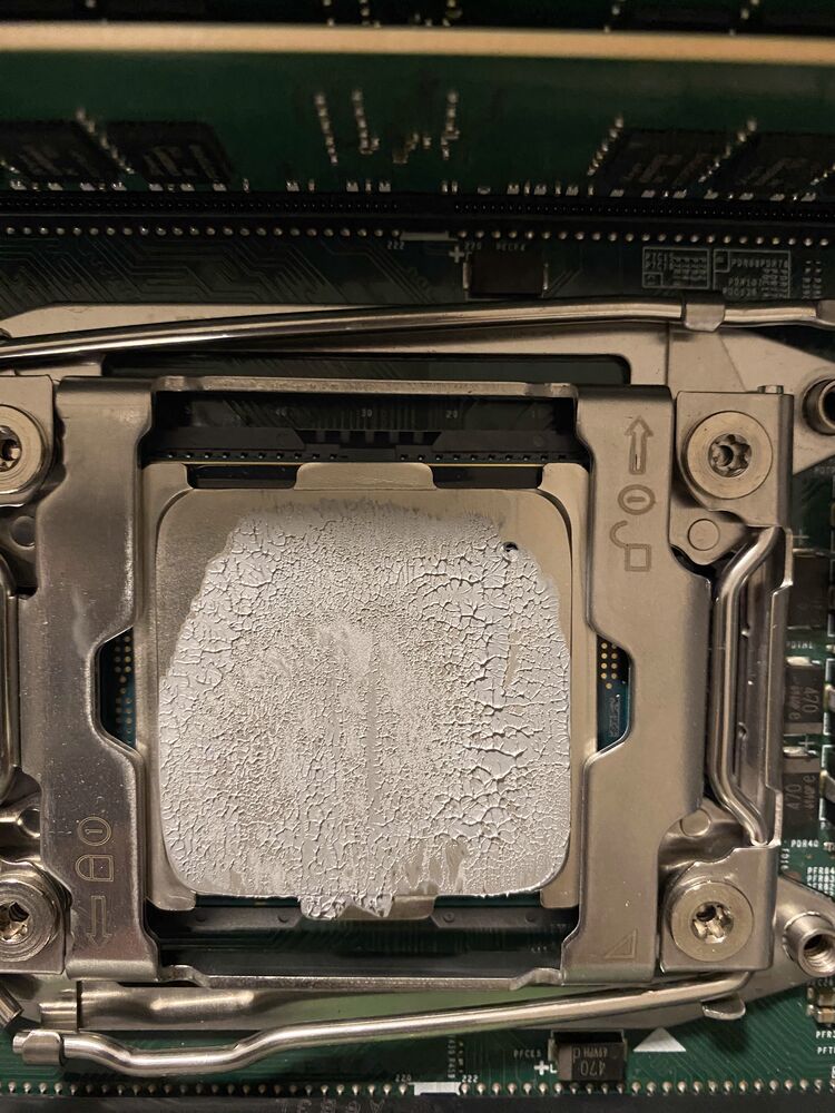 An open CPU socket with old thermal paste