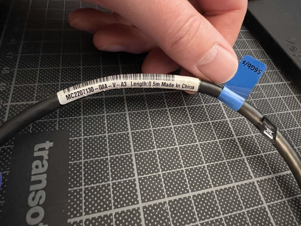 A short InfiniBand cable held in a hand