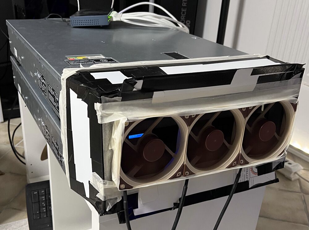 Three large fans taped to the front of a server